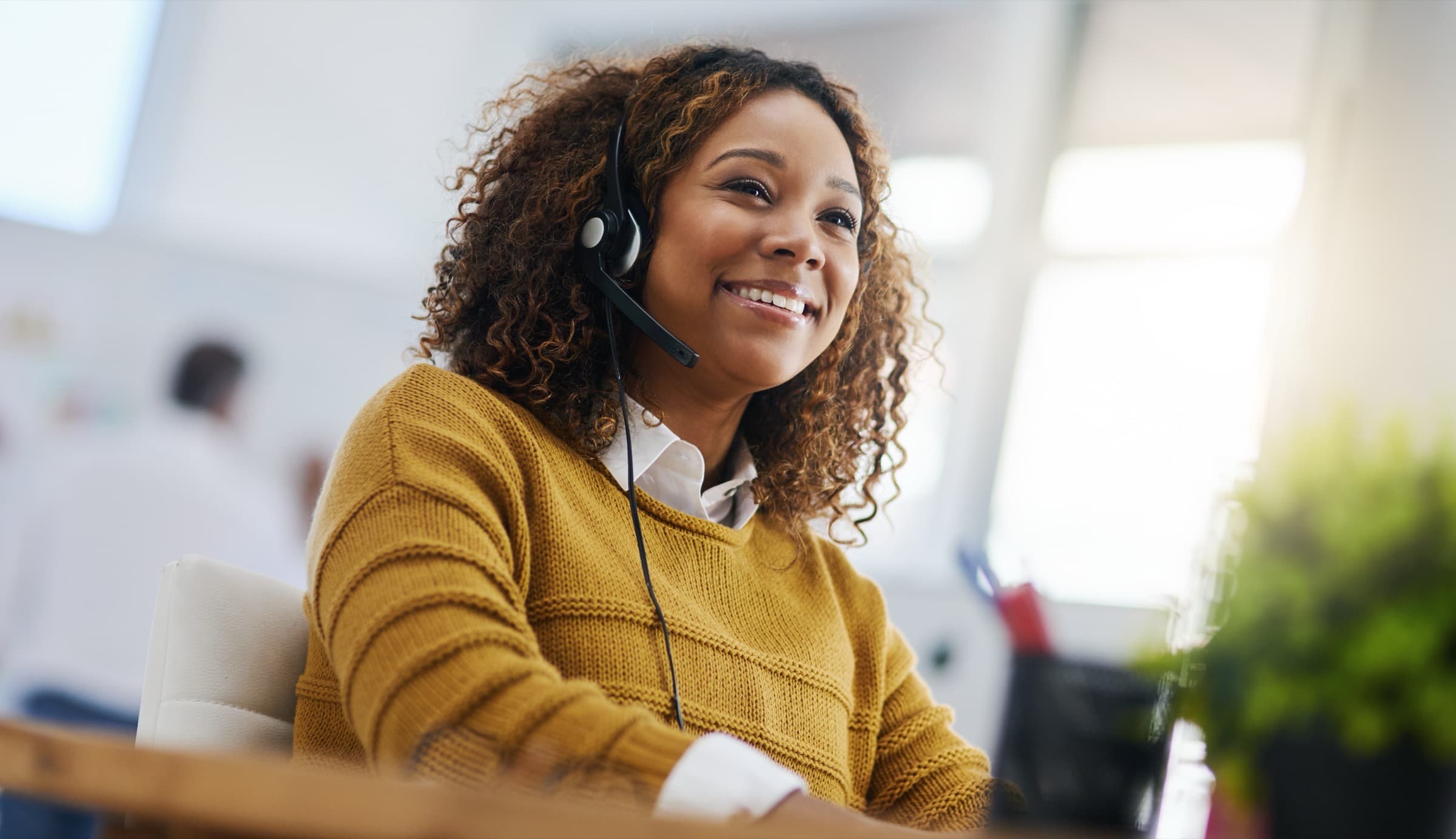 A benefit advocate wearing a headset, ready to help